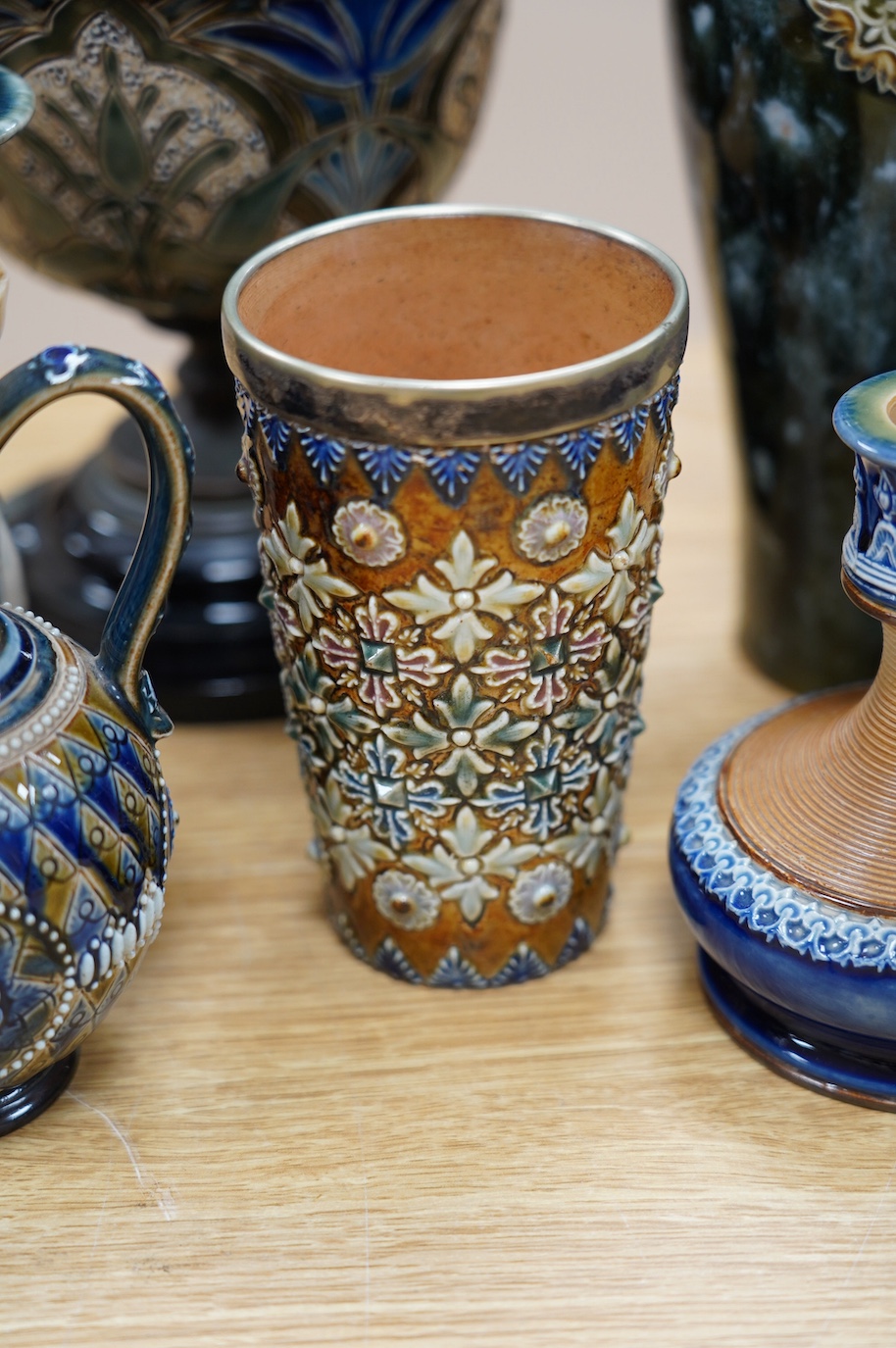 Seven Royal Doulton mixed vases etc, including two candlesticks, a pair of vases, a beaker, etc, tallest 21cm. Condition - the two handled pedestal jar has lost its lid, the other items are good